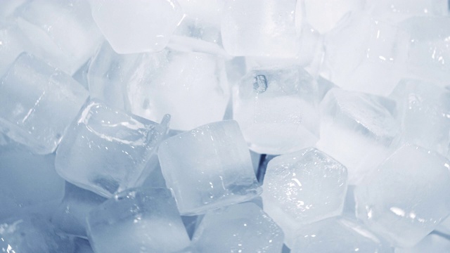 微距拍摄的冰块从清澈的水融化在白色的背景慢动作。概念:纯净的山泉水、冰、鸡尾酒、新鲜及冷冻食品。视频下载