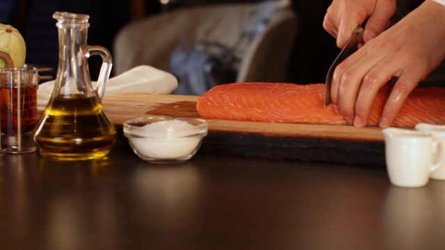 厨师切下一大块生鲑鱼片。高蛋白的食物。视频下载