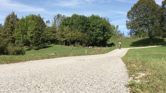在乡村公路上骑自行车的老人，探索乡村风景视频下载