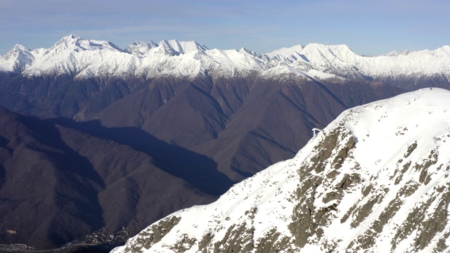 美丽的风景山与雪峰在天空背景无人机视图。从上面看，高雪山在蓝天的背景。冬脊谷视频素材