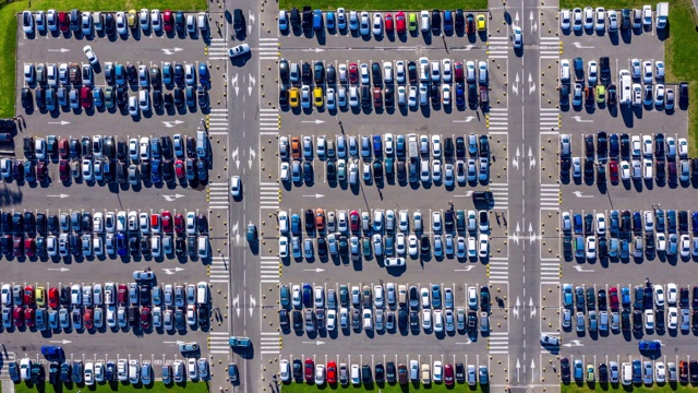 Timelapse汽车驾驶在商场停车场俯视图从飞行无人机。现代城市停车场上的汽车交通鸟瞰图。俯视图汽车移动和站在绿色停车场，时间推移视频下载