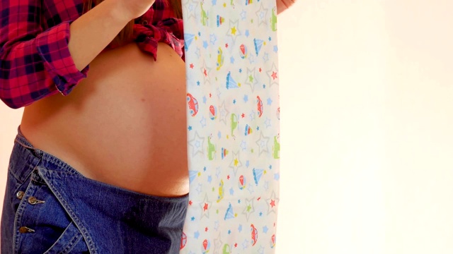 年轻孕妇为婴儿的出生准备襁褓。怀孕和母性概念。中景镜头视频素材
