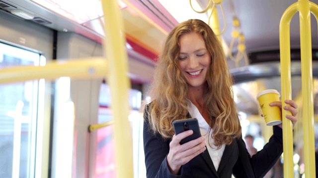 女商人在火车上使用智能手机视频下载