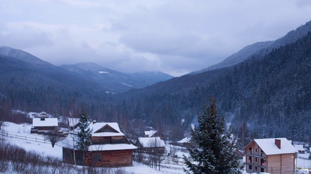 在被针叶林和雪山包围的山村山谷中，木屋的时光流逝。在滑雪胜地的小屋被雪覆盖的快速视图。昼到夜，夜到夜视频素材