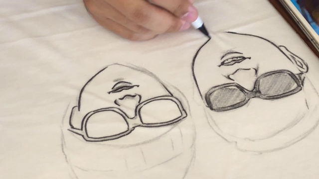 年轻女性专业设计师在白色t恤上绘制卡通人物视频下载