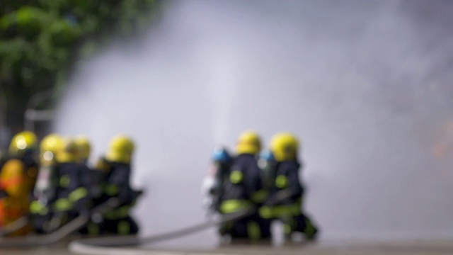 消防队员使用消防水龙带灭火的4K后视图视频素材