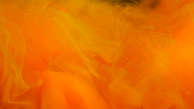 抽象的背景云橙色的颜料在水中轻轻旋转黑色，水下烟雾运动近观视频素材