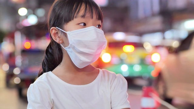 儿童女孩戴着防护面罩，防止呼吸有毒空气。环境污染，社会问题，生态灾害，交通，工业，能源，未来概念。关爱子孙后代。空气污染视频素材