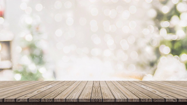 空的木制桌面与抽象的温暖的客厅装饰与圣诞树串轻模糊背景与雪，假日背景的广告产品展示视频素材