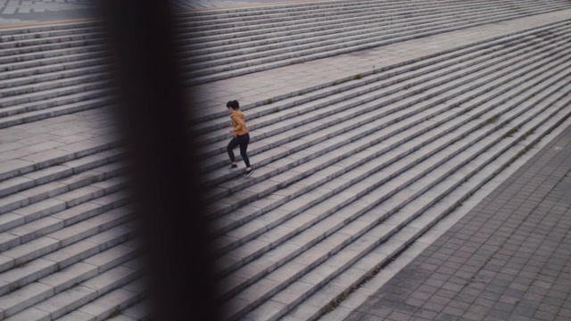 在日本东京，一名日本妇女穿着运动服跑上台阶。视频素材