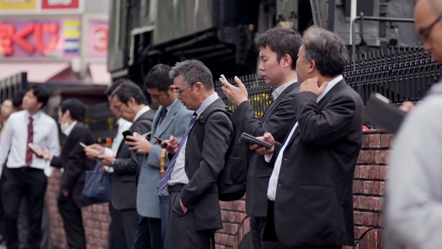 东京，西装男抽烟用智能手机视频素材