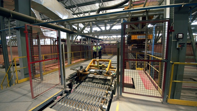 在工厂里，工程师们检查使用砖块的机器。视频下载