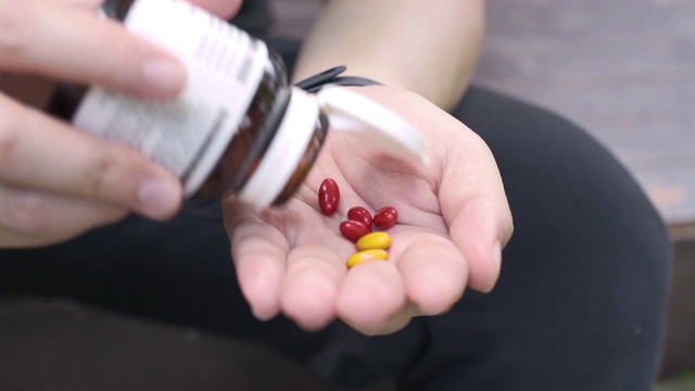 SLO MO从手边的药瓶中服用许多药物或维生素视频素材