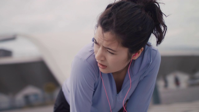 日本妇女在运动服装弯腰呼吸在东京，日本。视频素材
