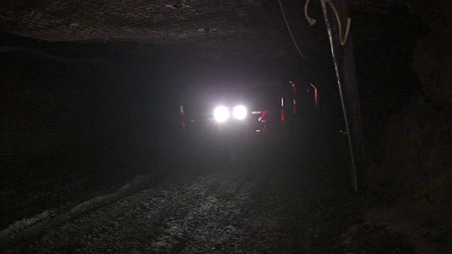 车头灯照在通过矿井的煤车上。视频下载