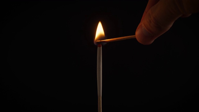 黑色背景上一根火柴上燃烧着孤立的火焰视频素材