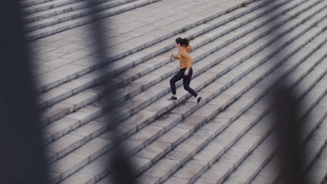 在日本东京，一名日本妇女穿着运动服跑上台阶。视频素材
