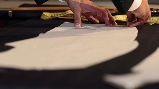 一名裁缝在织物上画线，并用他的粉笔在切口周围做一些修改的镜头视频素材