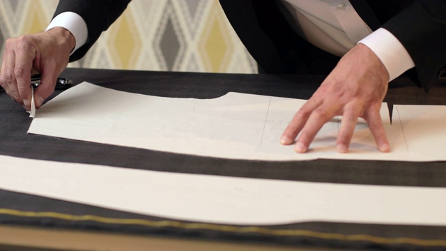一名裁缝在织物上画线，并用他的粉笔在切口周围做一些修改的镜头视频下载