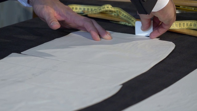 一名裁缝在织物上画最后的线条，然后将其切割成进一步加工的部分视频下载