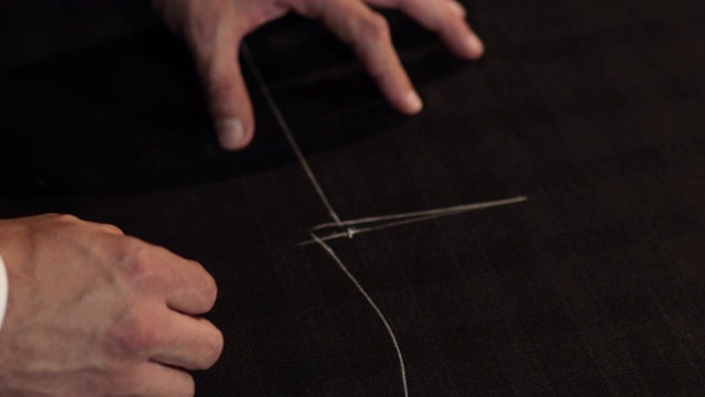 裁缝正在用粉笔在布料上画线，准备做一套衣服视频下载
