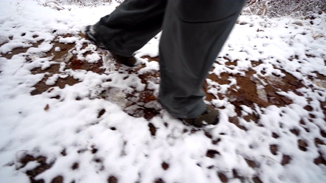 在一条被雪覆盖的山间小路上行走的徒步旅行者视频素材