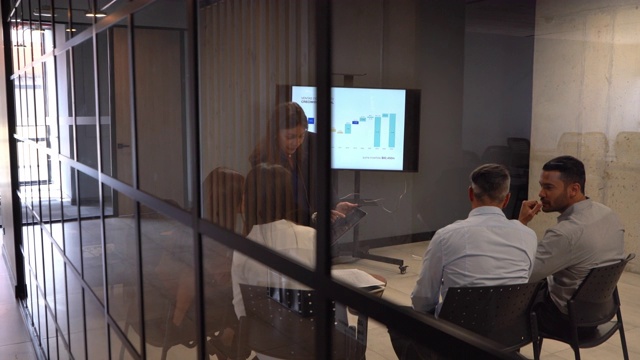 在办公室的培训课程中，自信的成年女性向她的团队展示平板电脑上的东西视频素材