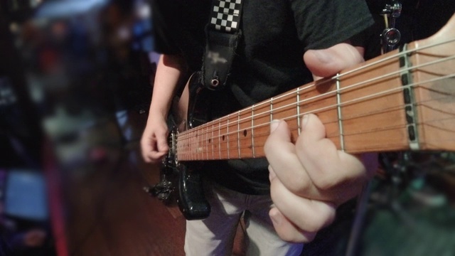 POV的观点，一个音乐家演奏电吉他摇滚明星青年青少年在一个摇滚乐队的舞台上。视频下载