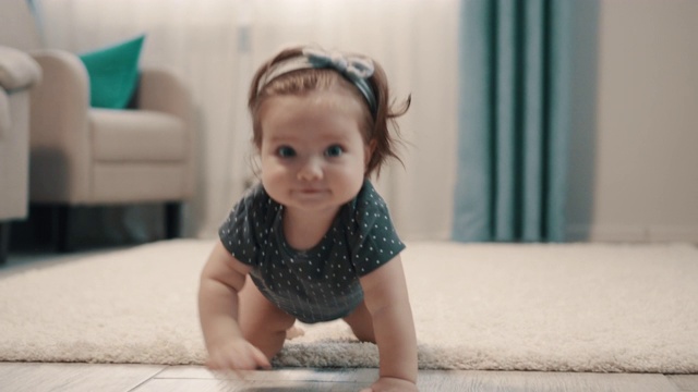 小女孩在家里的地板上用四肢爬行视频素材
