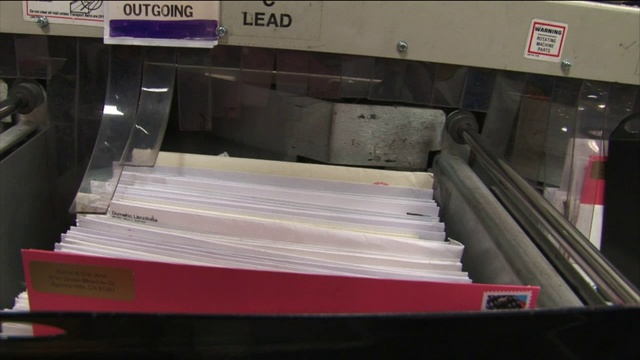 在邮政服务中心，一台机器把信件打包。视频素材