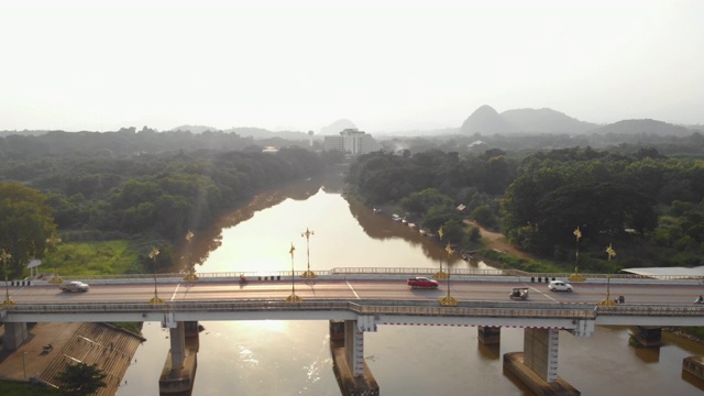 无人机起飞和跨越亚洲大桥，鸟瞰图跨越桥梁和河流，汽车，鸟瞰图交通过桥，清莱，泰国，东南亚，日落，黎明，黄昏视频素材