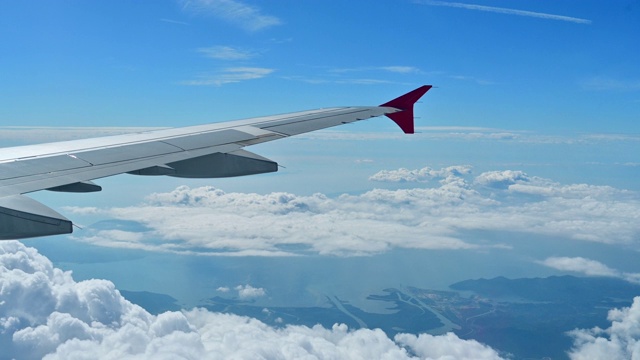 透过飞机窗口观看。美丽的白云在蓝天的背景。乘飞机视频素材