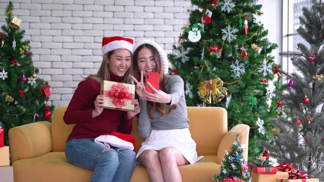 圣诞节期间，亚洲女性用手机展示礼物和自拍视频下载