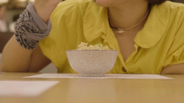 一个女孩在餐馆吃日本米饭视频素材