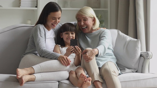 兴奋的多代女性家庭使用智能手机的乐趣视频素材