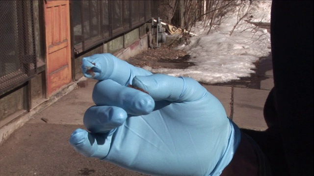 一位研究人员看着手套上的泥巴。视频下载