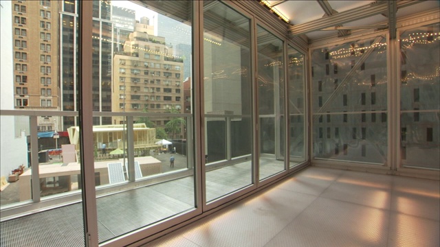 在一座未来主义风格的建筑中，走廊一端的窗户上覆盖着黑色标记。视频素材