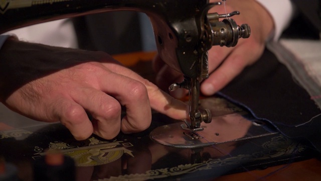 一个裁缝准备他的缝纫机工作的慢镜头视频素材