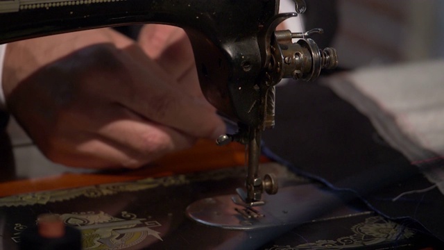 一个裁缝准备他的缝纫机工作的慢镜头视频素材