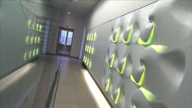 在一个现代建筑的走廊里，灯光会改变颜色。视频下载