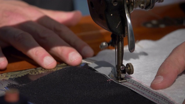 一名裁缝用缝纫机将两块布缝在一起的画面视频下载