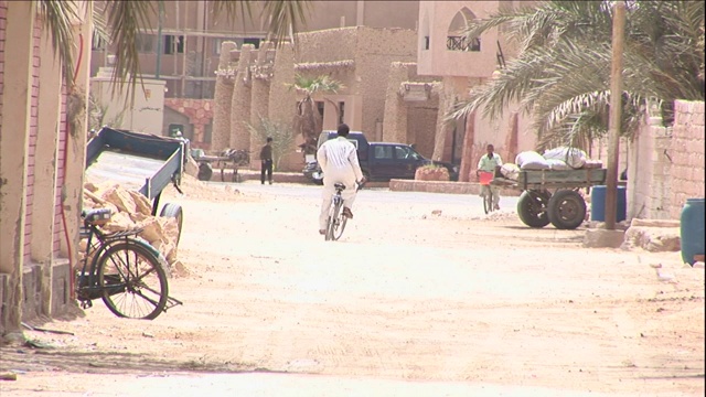 一个骑自行车的人在一条土路上行驶。视频下载