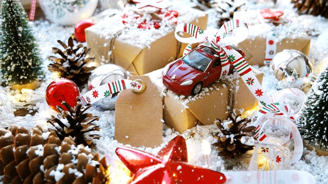 圣诞和新年背景与玩具车礼物用丝带。球，松果和不同的装饰在雪地上。视频素材