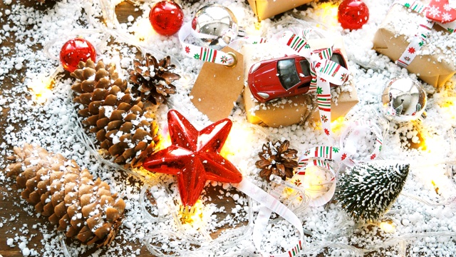 圣诞和新年背景与玩具车礼物用丝带。球，松果和不同的装饰在雪地上。视频素材