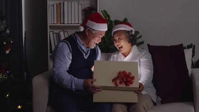 圣诞节庆祝;漂亮的老妇人收到来自丈夫的圣诞礼物很兴奋。视频素材