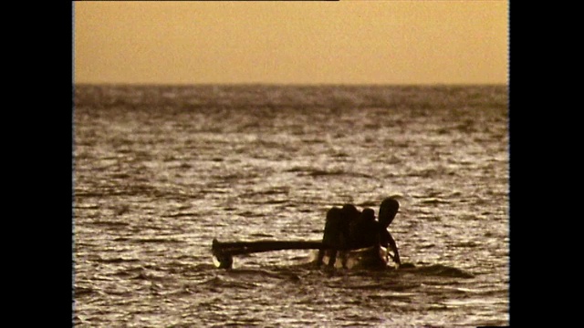 日落时分，人们划着独木舟的剪影;1983视频下载