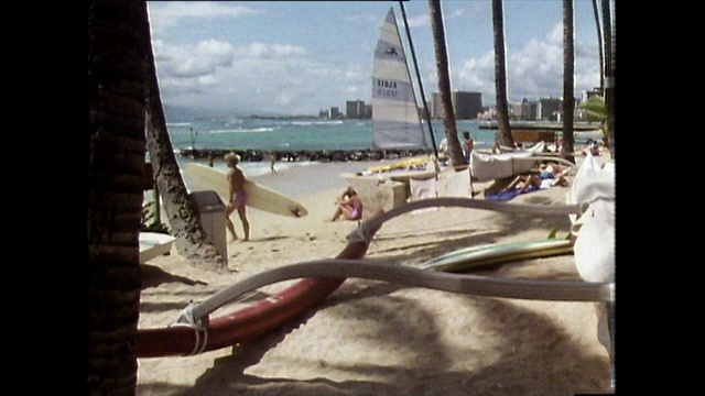 金发男子携带冲浪板走向海洋;怀基基海滩,1983视频下载