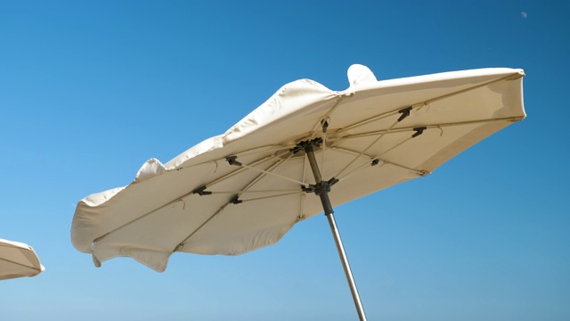 Costa del Maresme海岸。太阳伞在强风上挥舞的特写镜头。西班牙4 k。视频下载