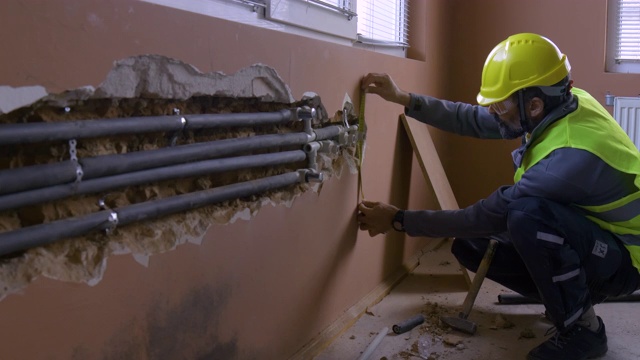修理房子。有经验的水管工在阳光明媚的日子在住宅建筑工地工作。视频下载