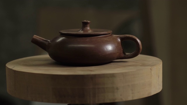 宜兴陶壶在木架上旋转。茶道用手工陶壶。4 k的视频。59.94帧/秒视频下载